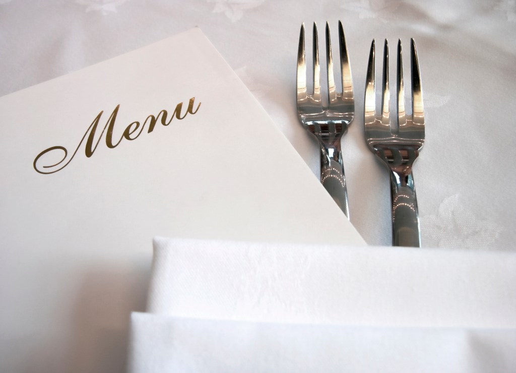 Menu and silverware close up on a dressed table